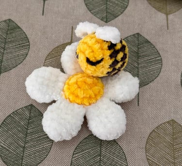 a handmade amigurumi stuffed daisy with bee toy 