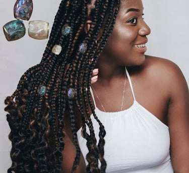 Woman with box braids displaying her jewel hair beads.