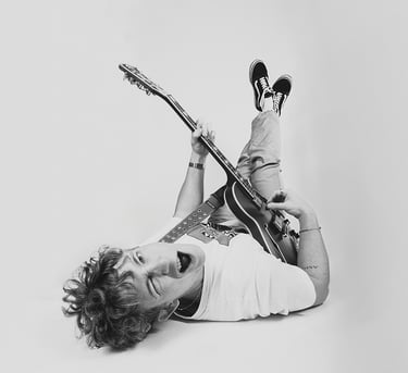 portrait of a man lying with a guitar and a guitar