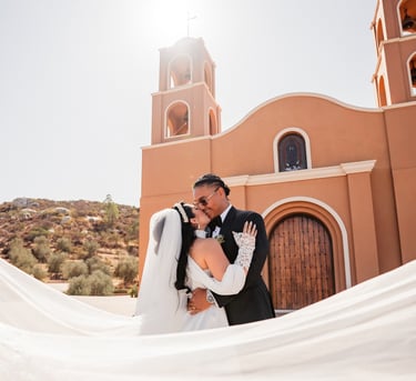 a bride and groom kissing in front of a church