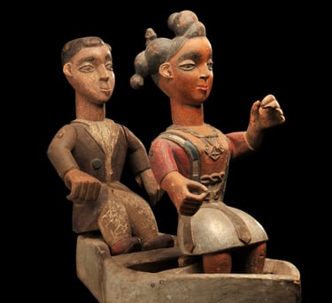 Cimier de danse figurant un couple de missionnaires sur une barque