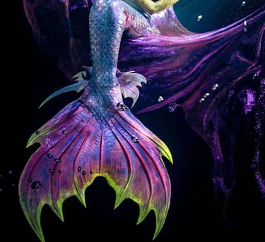 A dark purple and neon green tail by Mermaid Kat with multi colored ankle fins.