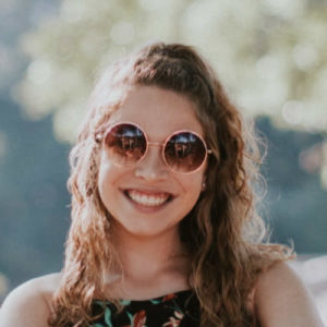 a woman in a floral dress and sunglasses