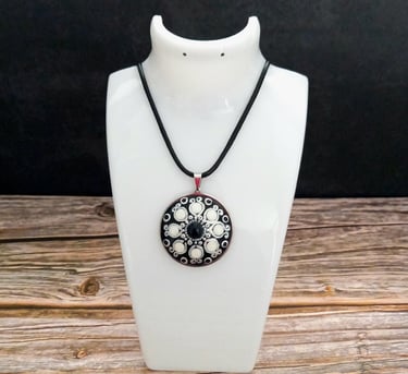 a necklace with a black and white flower pendant