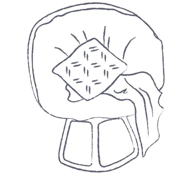 a chair with a pillow and draped blanket on it