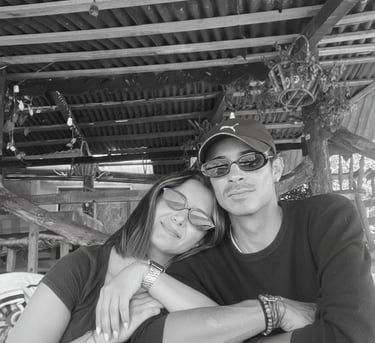  Fotografía en blanco y negro de una pareja linda con gafas de sol sentada en una mesa de patio 
