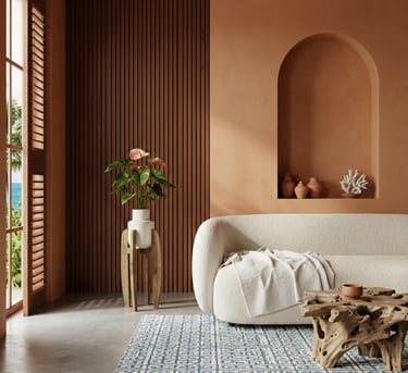 Salon méditerranéen moderne avec un canapé blanc courbé, des murs en terre cuite et un tapis bleu