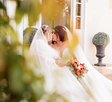 a bride and groom kissing on the porch