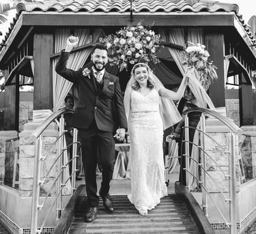 a bride and groom walking down a bridge