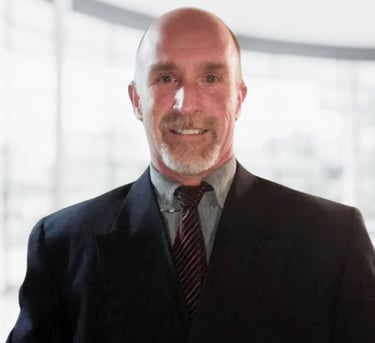 Richard in a suit and tie smiling