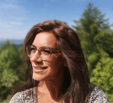 a woman with glasses and a floral top