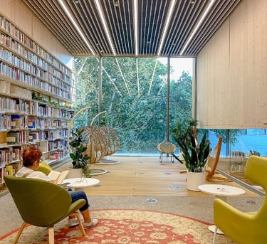 Espacio interiores de una biblioteca en la que se aprecia una persona leyendo