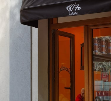 Fachada de una cafetería en la que se ve una persona dentro