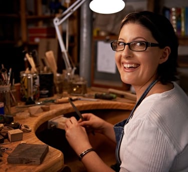 Joyero artesano que utiliza una lima de mano en un banco de trabajo profesional en un estudio de