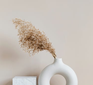 Un elegante vaso bianco con grano, evocando la tranquillità e il design minimalista di Borganthia 