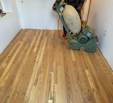 a man in a black jacket is using a machine to remove wood floors