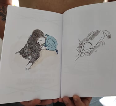 a person holding a book with a drawing of a cat