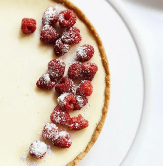 a dessert with raspberries and sugared cream