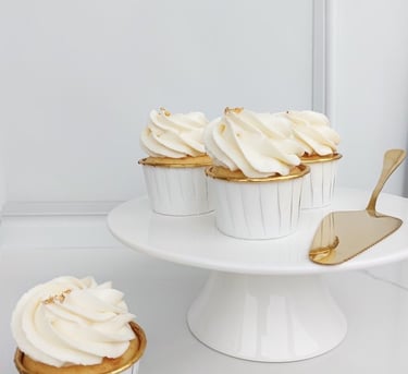 a cake with white frosting and cupcakes