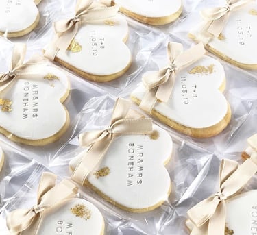 a bunch of cookies that are decorated with gold and white