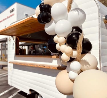 a food truck with balloons party planner