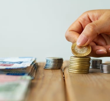 dinheiro e moedas sobre uma mesa de madeira