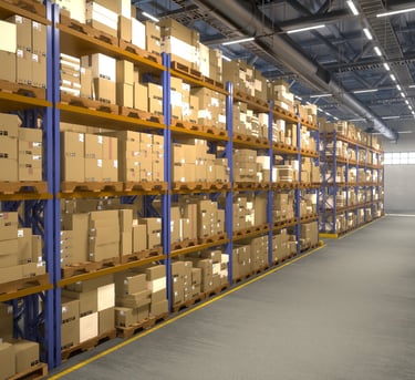 Caixas de papelão empilhadas em paleteiras metálicas industriais em um galpão de distribuição