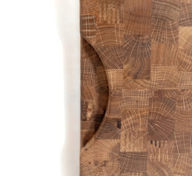Close-up of the recessed handle and end-grain pattern of a wooden chopping board