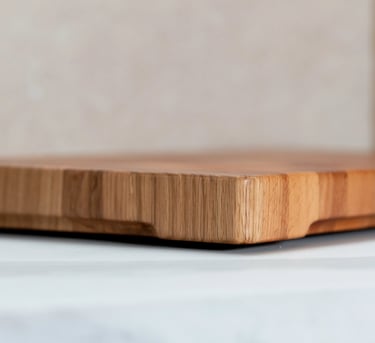 Close-up of a thick end-grain wooden chopping board showing its rounded edge