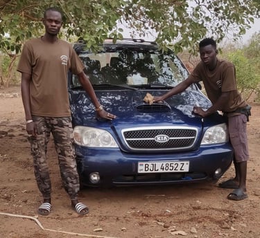Team members of Birding Adventures Gambia & Senegal posing with a blue Kia safari vehicle, used for 