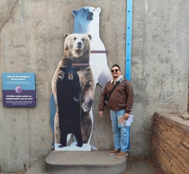 Luis standing next to a trio of bear cutoffs to compare his height.
