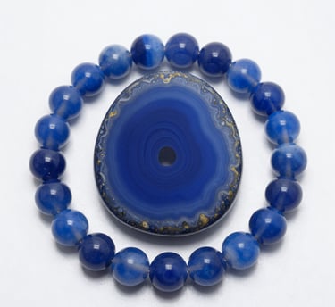 Polished moonstone crystal heart surrounded by a beaded blue lace agate gemstone bracelet.