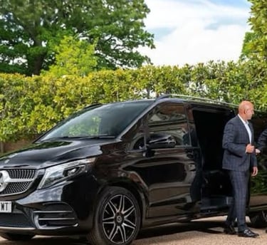 a man in a suit and tie standing next to a van