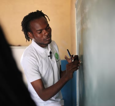 a man in a white shirt is writing on a blackboard