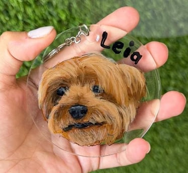 Un llavero personalizado de acrílico transparente con el retrato pintado a mano de un perro terrier 