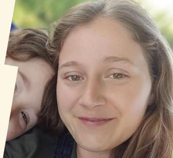 Smiling woman with light brown hair posing for a close-up portrait outdoors with a young child.