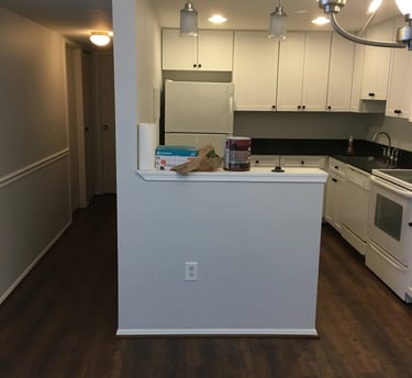 Dark wood-look vinyl plank flooring installed through the hallway, kitchen, and dining area.