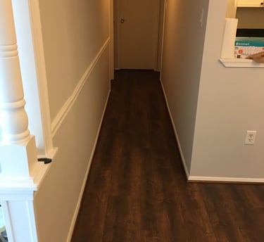 Dark wood-look vinyl plank flooring installed through the hallway.