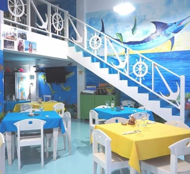 Sala ristorante dell'Hotel Big Game Maio con decorazioni marinare e murales.
