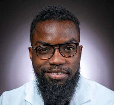 a man with a beard and glasses on a white coat