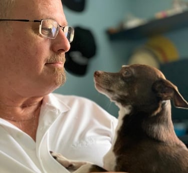 a man in a white shirt is holding a dog