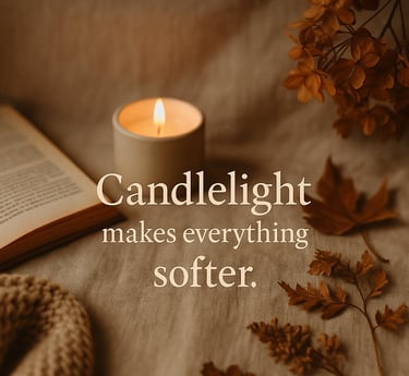 Candlelit fall flat-lay with an open book, knit blanket, and dried leaves