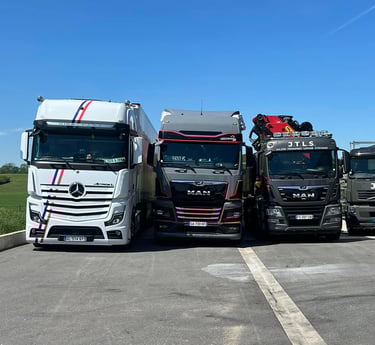Flotte de camions JTLS stationnés, prêts pour des opérations de transport et levage