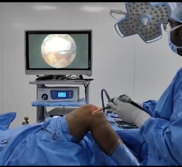 Surgeon performing minimally invasive arthroscopic surgery on a patient's knee.
