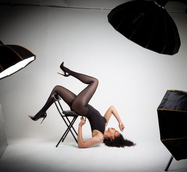 a photo studio with a model posed on a chair