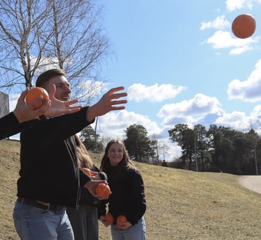 jauni vaikinai gaudo apelsinus