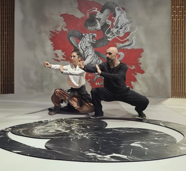 Ismet Himmet and Gizem Kara practicing a Tai Ji form on a yin-yang mat before a dragon mural.