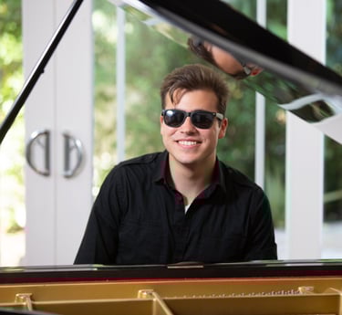 Daine Jordan on the piano with sunglasses