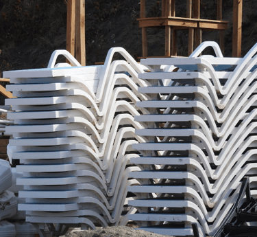 a pile of plastic chaise lounges chairs with plastic chairs