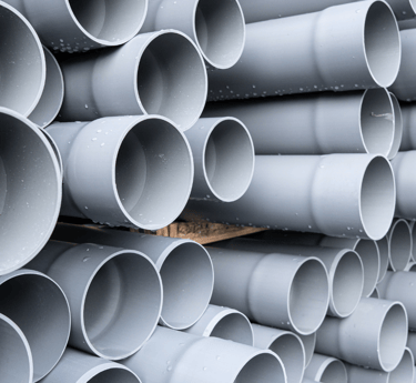 a stack of plastic pipes and pipes in a pile